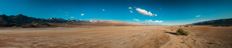 A depiction of a vast desert landscape with sand dunes and a clear blue sky.